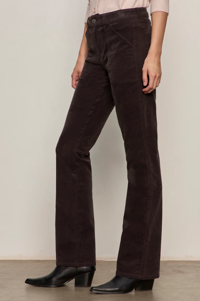 Person wearing brown corduroy pants with a plain background