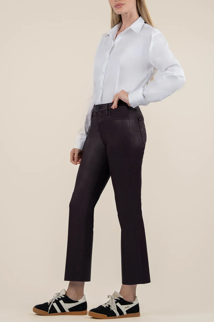 Person wearing a white shirt and black pants on a beige background