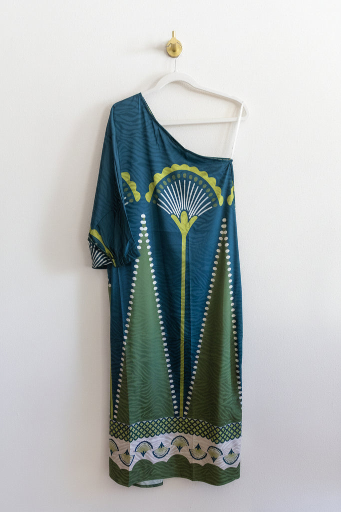 Green patterned dress hanging on a white wall