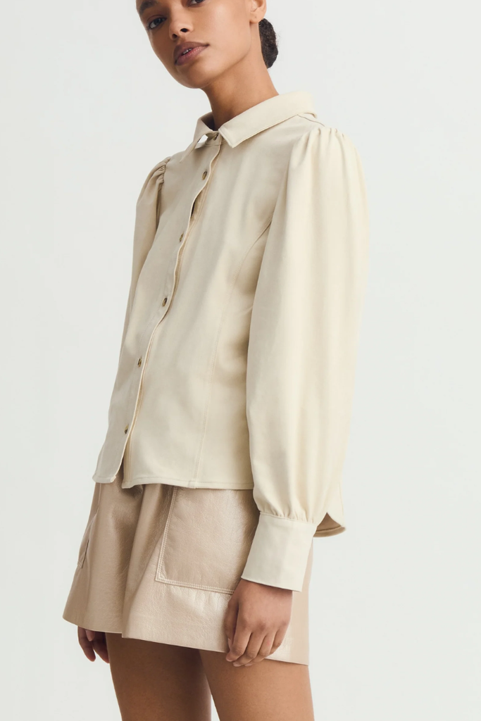 Woman wearing a beige shirt and skirt set on a white background